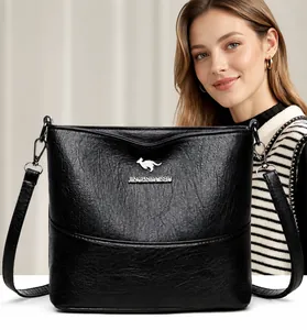 Detail of black leather bucket bag featuring silver kangaroo logo and wide shoulder strap