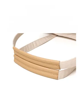 Close-up of reinforced stitching on beige canvas shoulder straps with khaki leather accents
