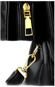 Détails d'un sac en cuir noir avec ferrures dorées polies et fermetures éclair