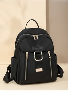 Detailed view of the black waterproof nylon backpack featuring elegant gold-tone zippers