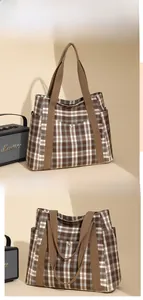 Detail view of plaid tote bag featuring functional side pockets and sturdy woven handles