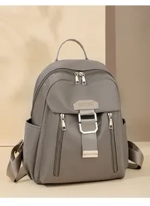 Detail of grey waterproof nylon backpack featuring metal buckles and vertical zipper pockets