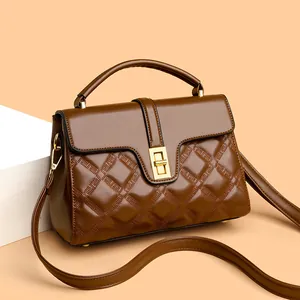 Sac bandoulière vintage marron matelassé avec fermoir doré et poignée sous un angle de 45 degrés