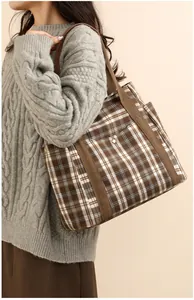 Brown checkered tote bag with large capacity and shoulder strap shown on a model