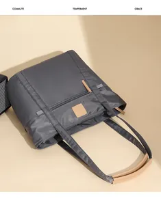 Detail view of charcoal tote bag with premium brown leather handles and waterproof nylon fabric
