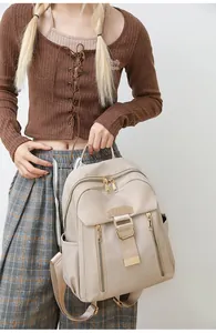 Detail of beige waterproof nylon backpack with gold metal hardware and ADULE logo