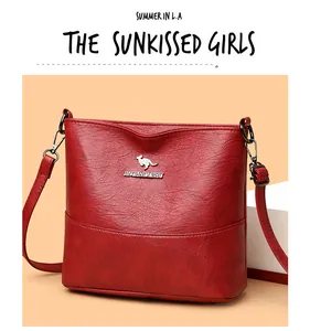 Detail of red pebbled leather bucket bag featuring silver kangaroo logo and hardware