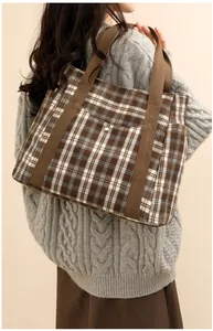Detailed side view of a large vintage plaid tote bag with pockets and sturdy canvas handles