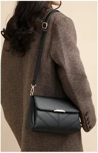 Detail view of black lychee grain texture with gold hardware and V-shaped stitching