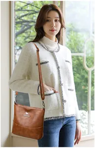Brown faux leather crossbody bucket bag with silver metal kangaroo logo and wide strap