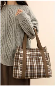 Macro detail of checkered tote bag showing textured fabric and front pocket with metal snap