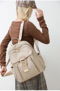 Close-up of beige waterproof nylon backpack with gold zippers and multiple pockets