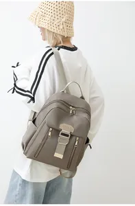 Detail of taupe waterproof nylon backpack with gold zippers and leather trim by ATULZ
