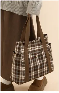 Macro detail of the side storage pocket and canvas material of the plaid tote bag