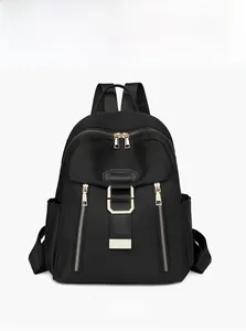 Close-up of black waterproof nylon backpack with gold zippers and metal D-rings