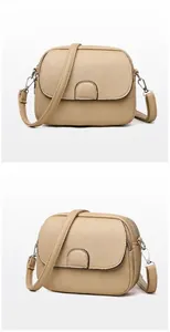 Close-up of apricot cross-body bag with litchi grain texture and metallic details
