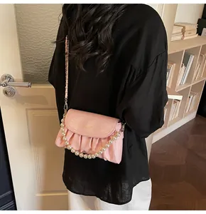 Détail du sac nuage plissé rose avec poignée en perles et chaîne sur le mannequin