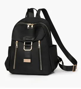 Side view of black nylon travel backpack with golden zippers and fabric texture details