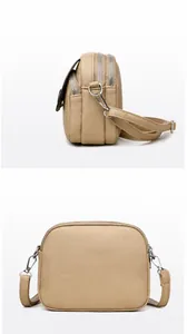 Macro detail of khaki camera bag showing triple zippers and lychee grain leather texture