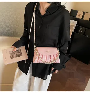 Détail du sac nuage plissé rose avec chaîne de perles et bandoulière en style de vie