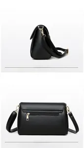 Detail view of the black textured leather crossbody bag with back zipper and side gold buckle