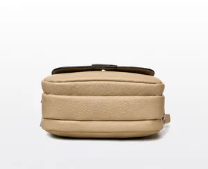 Macro view showing the dual compartments and pebble grain texture of the beige mini bag