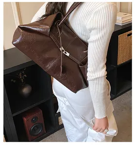 Detail showing deep brown oil-wax leather texture and silver metal buckle on tote bag