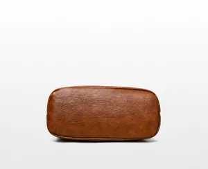Close-up of the oval bottom display of the brown bucket bag with lychee grain texture
