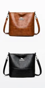 Close-up of brown and black bucket bags with litchi texture and metal kangaroo logo