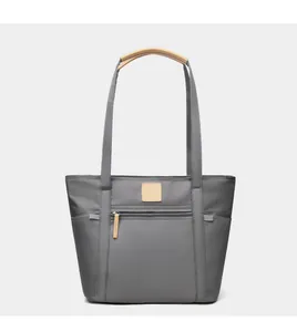 Close-up of grey waterproof nylon tote bag with leather handles and side pockets
