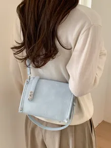 Light blue pleated shoulder bag with silver hardware on model in a minimalist setting