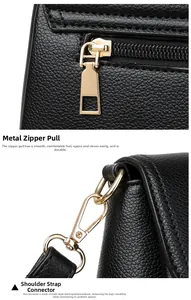Close-up of golden hardware zipper and strap buckle on black lychee grain leather bag