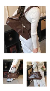 Detail of dark brown tote bag showing glossy textured leather and metal buckle strap