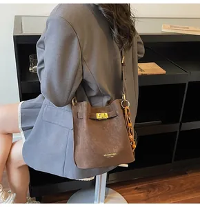 Detailansicht der braunen Beuteltasche mit Holzperlenanhänger und Metallverschluss