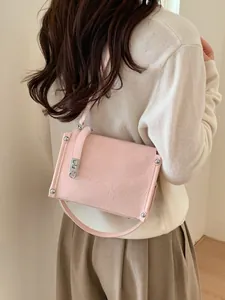 Pink minimalist baguette crossbody bag with pleated texture and silver twist lock on model