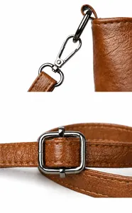 Macro detail of adjustable brown leather strap with gunmetal hardware for bucket bag