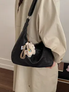 Minimalist black leather dumpling bag for women with cute white lamb plush pendant