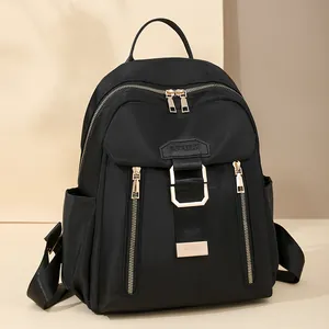 Waterproof black nylon travel backpack with gold zippers and multi-pocket design for women