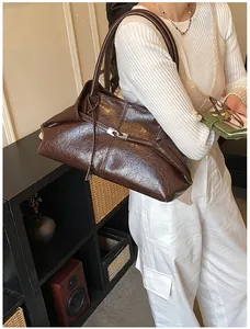 Detail of dark brown wax leather tote with vertical stitching and silver metal buckle