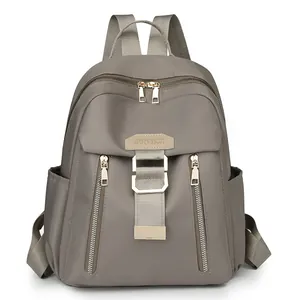 Waterproof taupe nylon travel backpack for women with gold zippers and multi-pocket design
