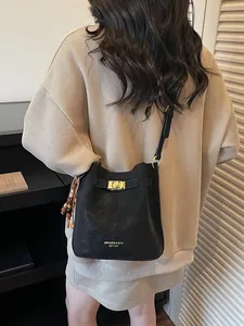 Schwarze Bucket-Tasche im Retro-Stil mit Goldschloss und bunten Perlen am Model getragen