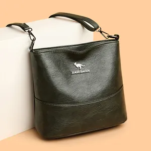 Minimalist forest green bucket bag for women with wide shoulder strap and kangaroo logo
