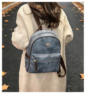 Outdoor model shot of blue-grey embossed floral leather backpack with brown straps