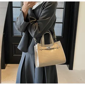 Détail du sac à main en cuir PU beige avec fermoir argenté et bandoulière réglable