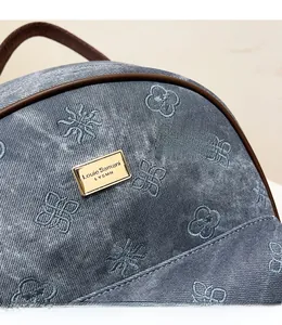 Close-up of jacquard fabric with floral embroidery and golden brand logo on tote bag