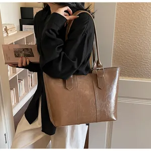 Détail de la texture cuir huilé vintage et boucle métallique sur grand sac cabas