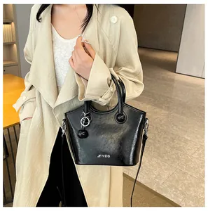 Λεπτομέρεια μαύρης λουστρίνι τσάντας κουβά με ασημί λογότυπο και σφαιρικό διακοσμητικό