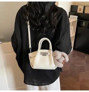 Rear view of white lychee pattern bucket bag with rabbit charm and silver twist lock