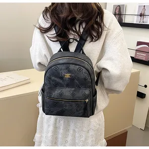 Detail of grey embossed floral backpack with golden hardware and front zip pocket