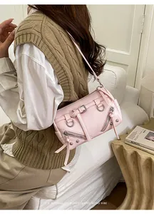 Detailed view of pink biker bag with silver zippers, buckles, and metallic rivets